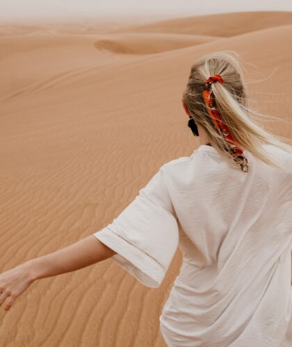 United Arab Emirates, Dubai, Lahbab Desert, woman walking in desert landscape